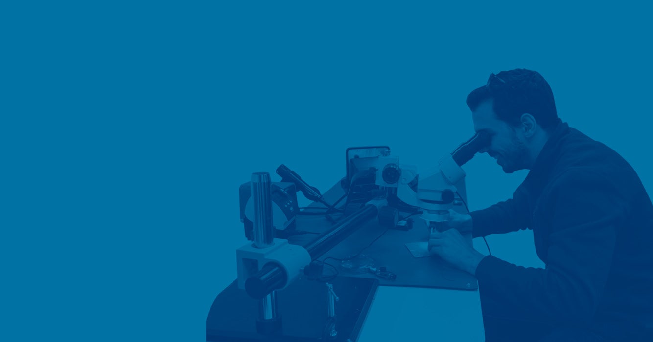 man using microscope