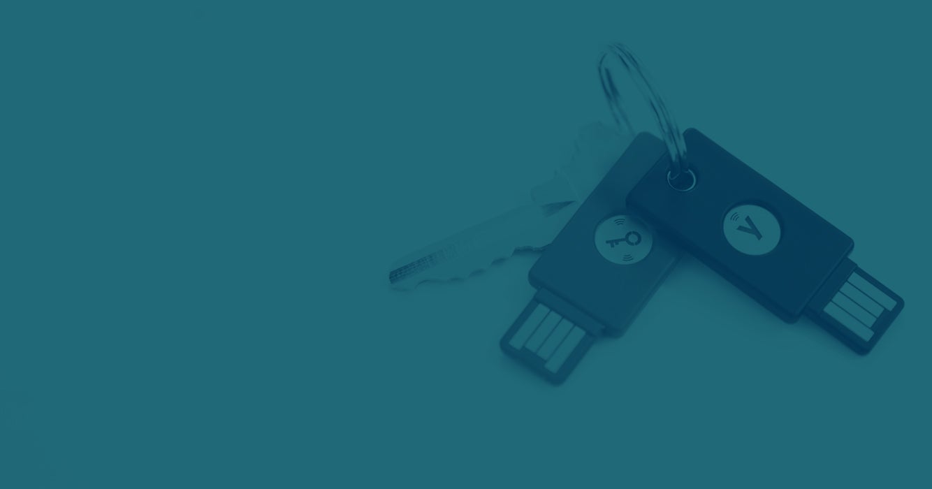 Two YubiKeys on a keychain with a key
