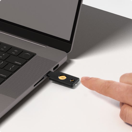 Finger touching YubiKey in computer