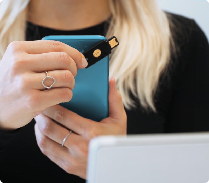 woman using mobile device and YubiKey 5 NFC